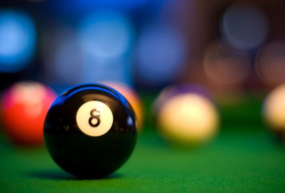 An eight ball on blue cloth